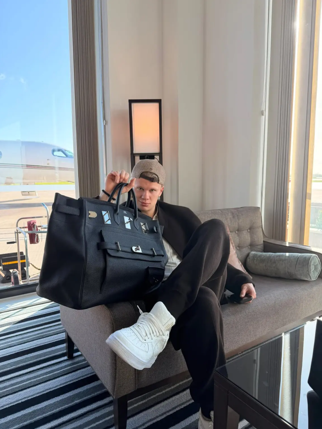Erling Haaland sentado junto a un gran bolso Hermès negro