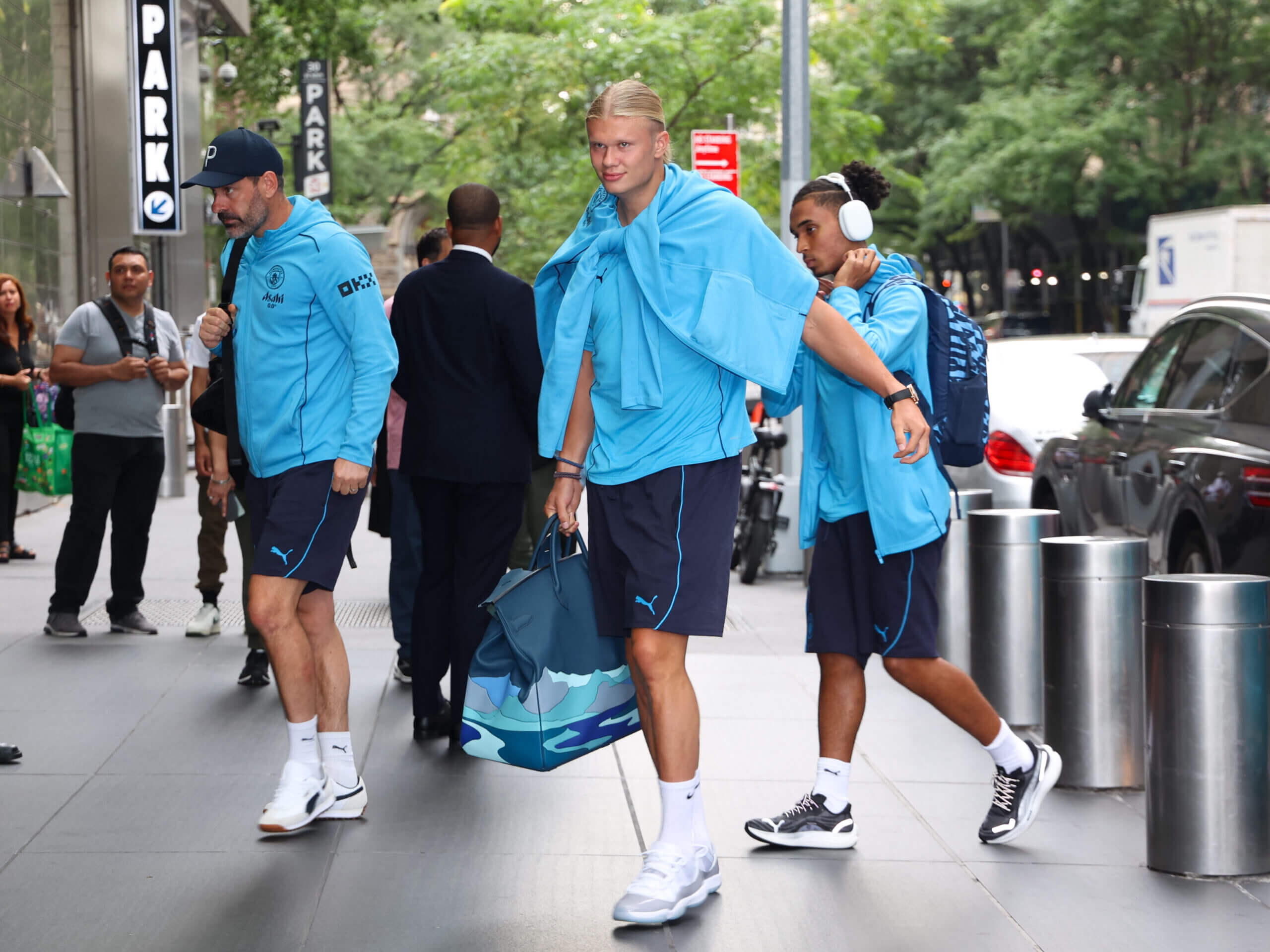 Erling Haaland vestido de azul con un bolso de paisaje