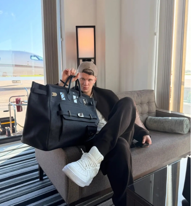Erling Haaland sentado mostrando un gran bolso Hermès negro